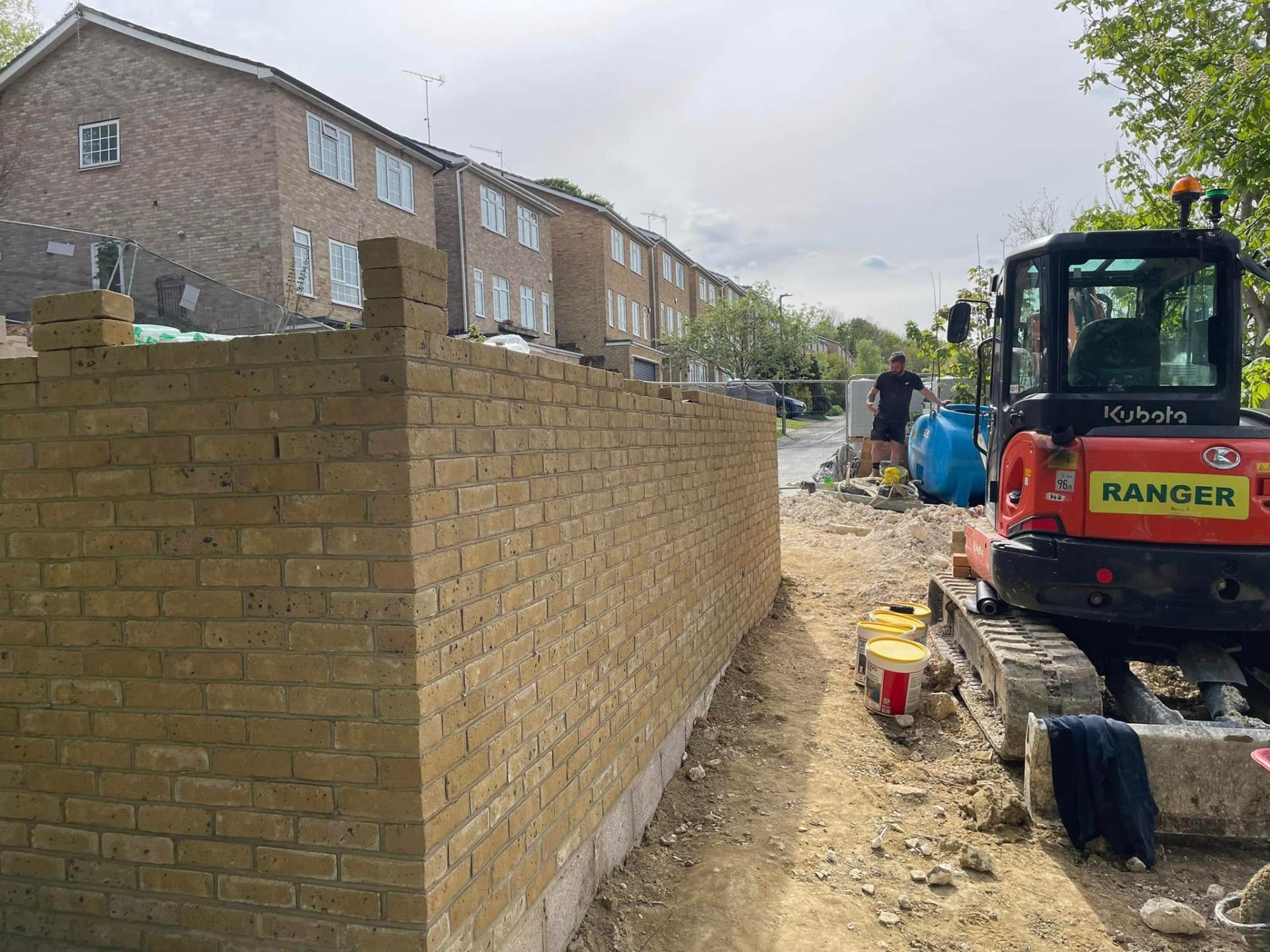 New brick wall construction with digger on site — Philbert Construction brickwork project in Reading & Berkshire